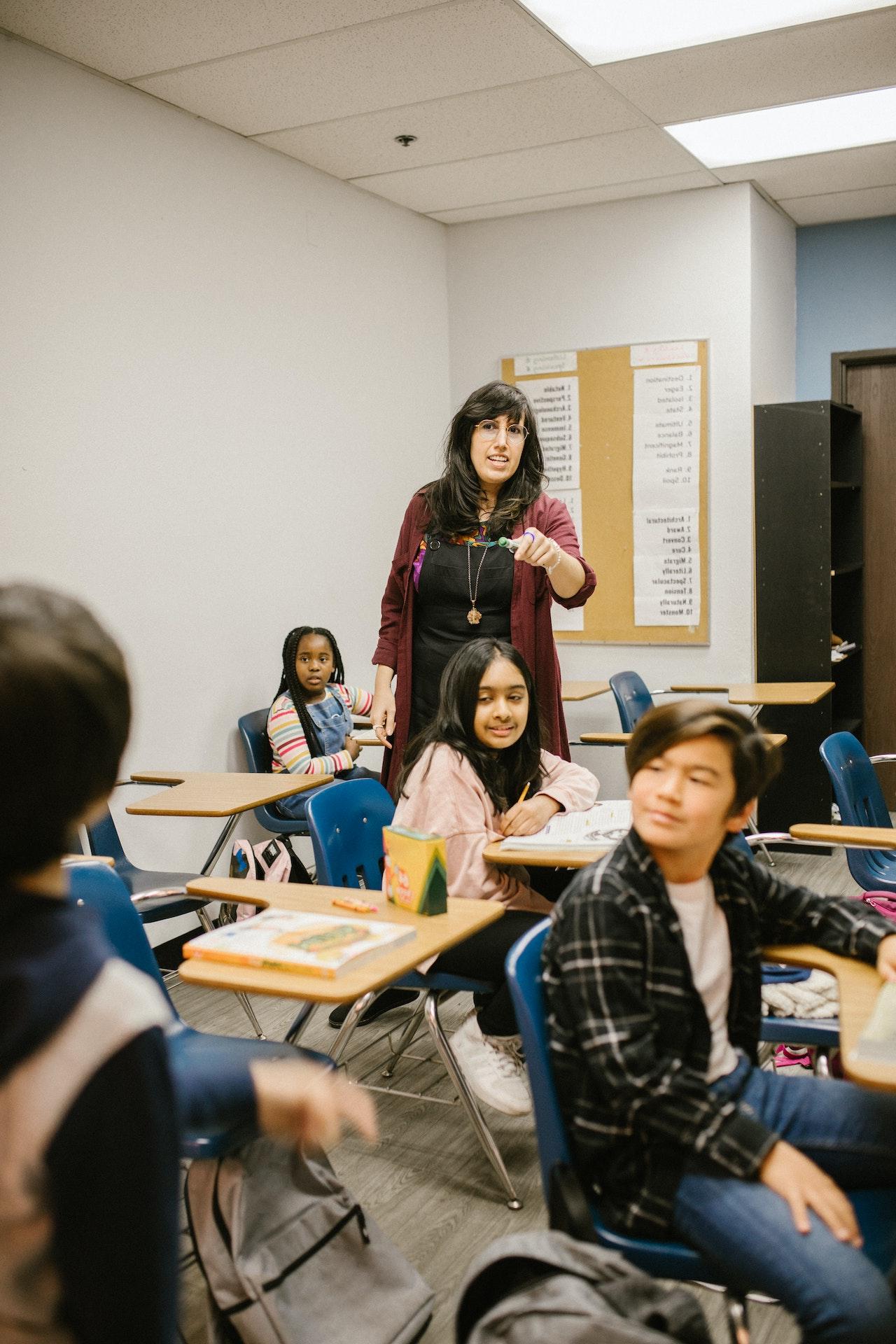 A teacher pointing at a student, calling on him