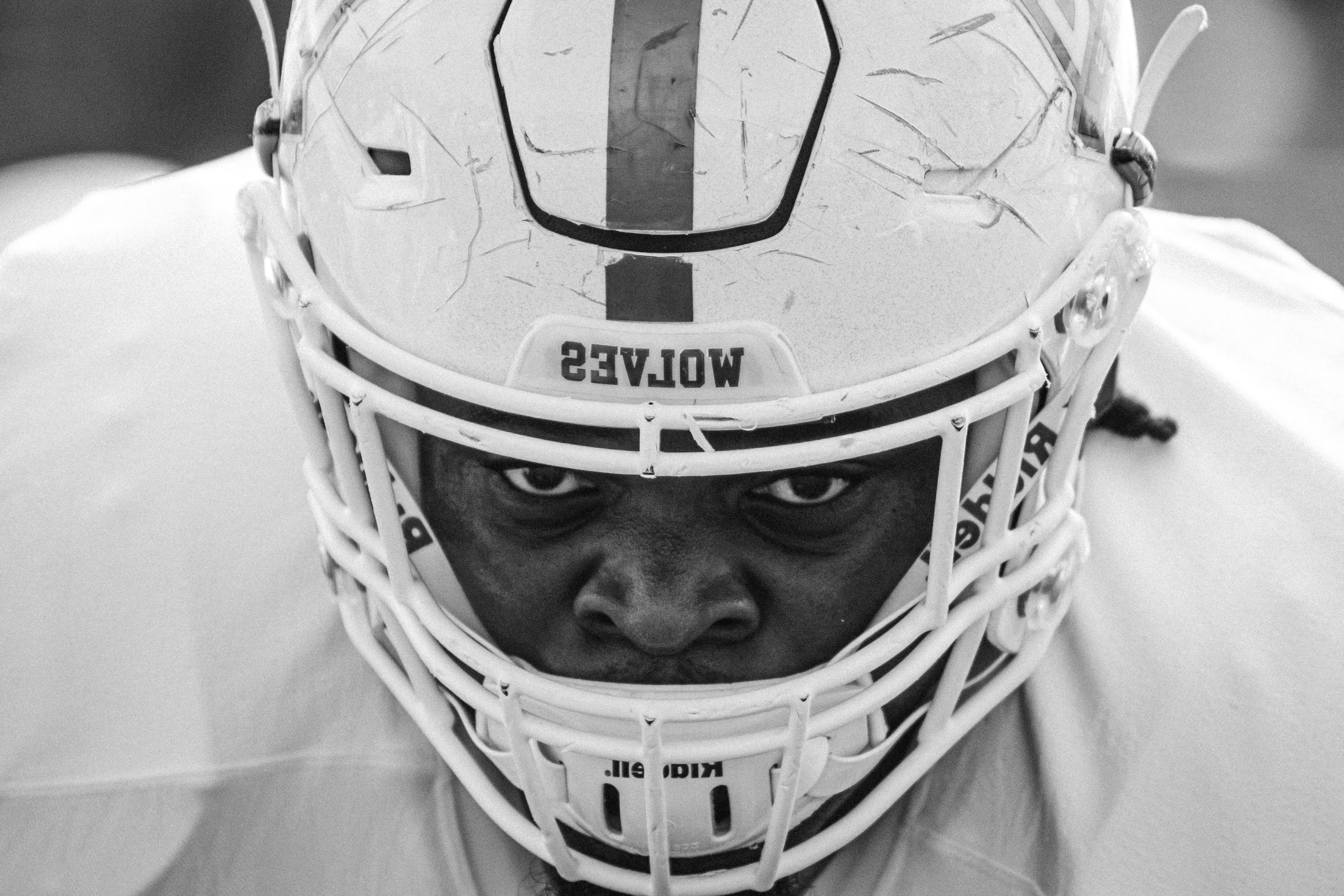 Football athlete closeup showing him wearing his football helmet with Wolves written across the front.